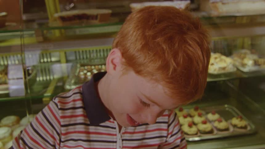 A boy eating cake at a bakery