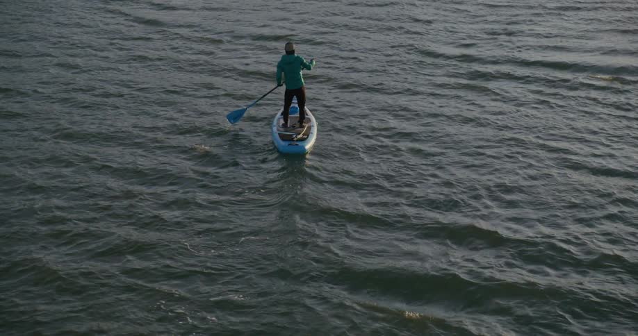 Man on a stand up paddle board at sunset on the San Francisco Bay