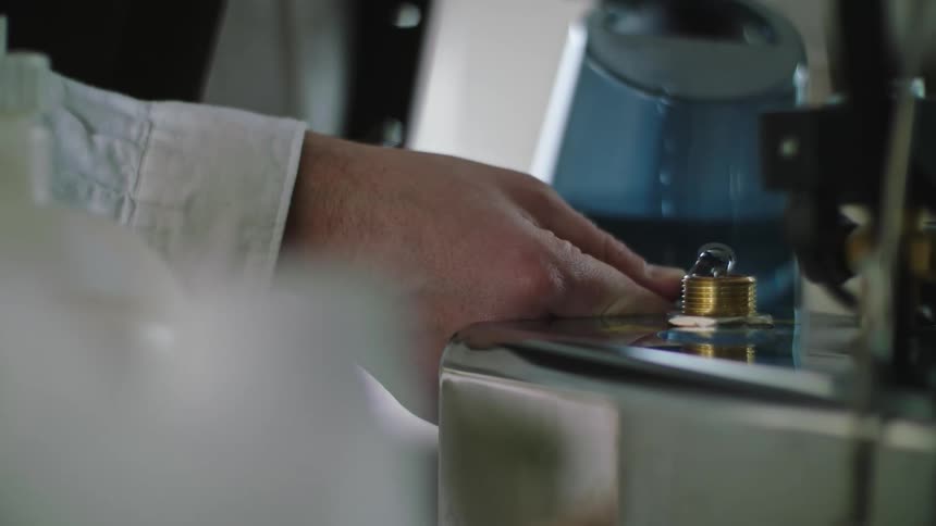 Closeup of a hand pouring water into a machine