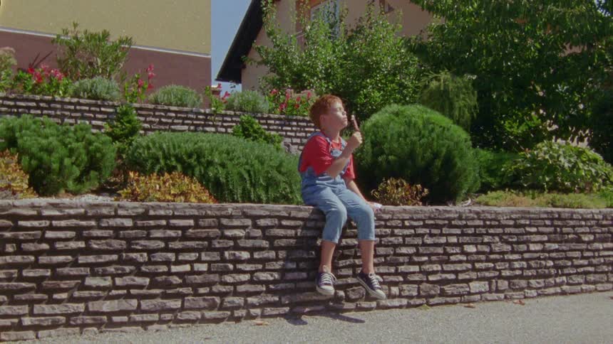 A boy eating ice cream on a hot summer day
