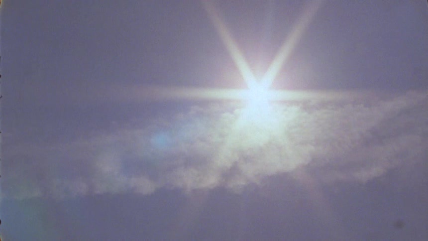 Sun with sunrays on a day with few clouds