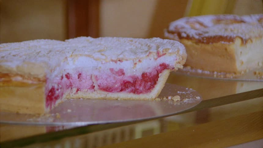 Two small cakes side by side on top of a glass shelf