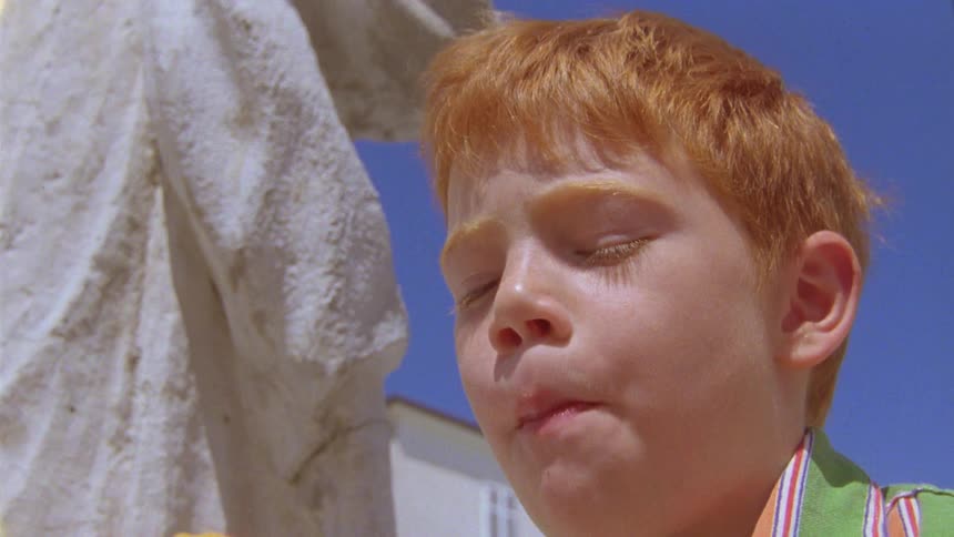 Redhaired boy eating a peach
