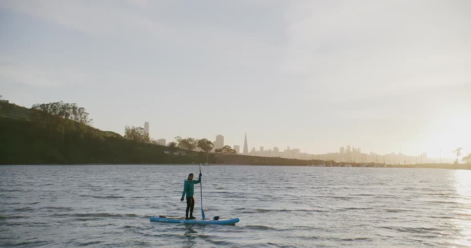 Man on a stand up paddle board on the San Francisco Bay at sunset