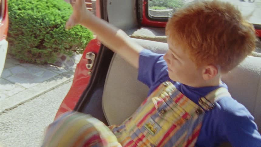 A child gets into the car and waves