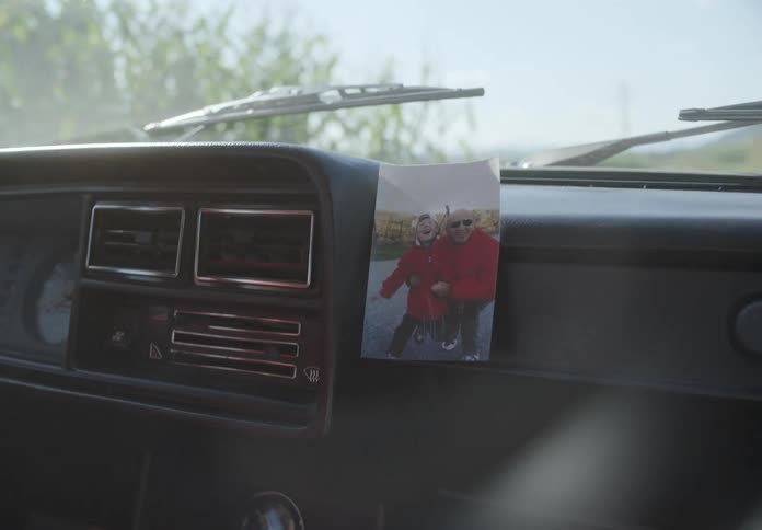 Interior of a car in motion with a picture attached to the dashboard