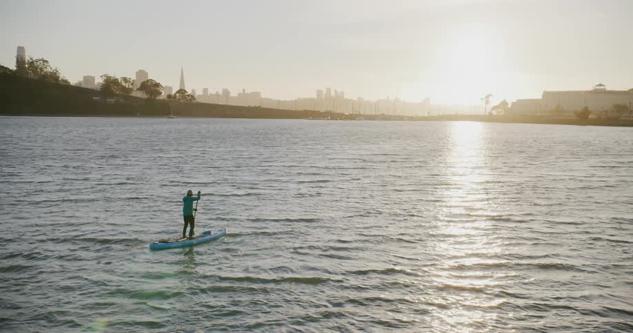 A person on a stand up paddle board on the San Francisco Bay filmed as an aerial dolly zoom