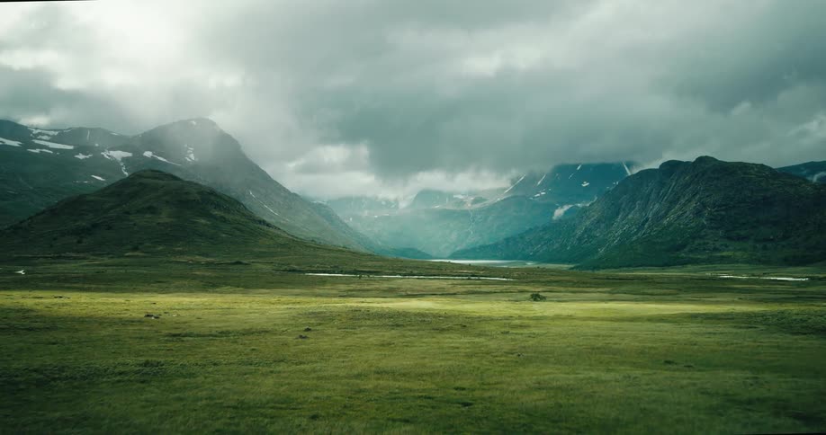 Pasture lake and mountains with a bit of snow in a natural landscape