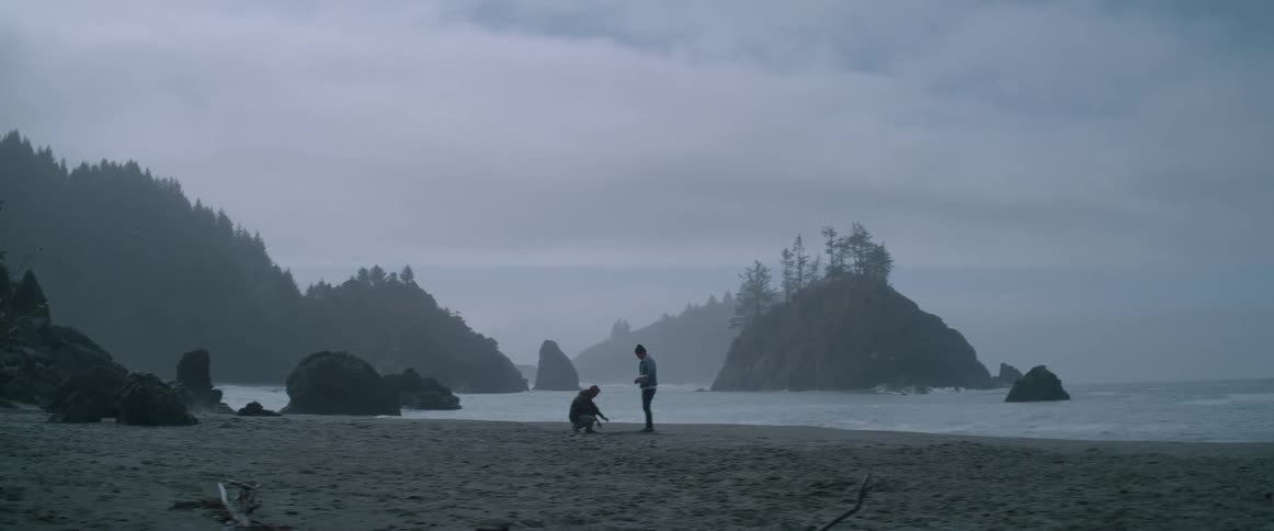 Sad people at the seashore during a cloudy dawn