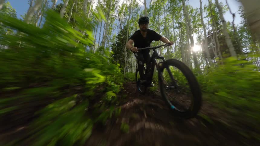 A person practicing cycling in offroad terrain in the middle of the forest