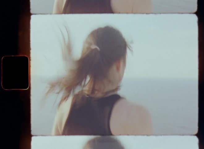 Brunette woman with long brown hair in ponytail doing jumping jacks in an outdoor environment overlooking the sea as part of her daily morning routine for a healthy lifestyle and active life with health and joy through endorphin and dopamine