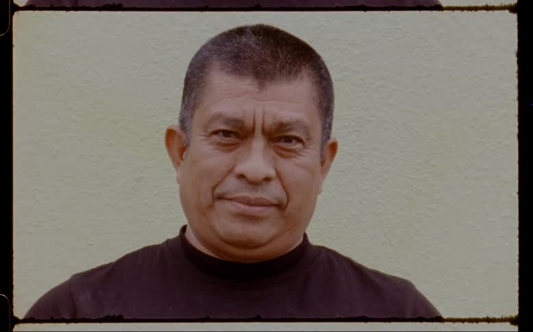Closeup of a mans face giving a slight smile