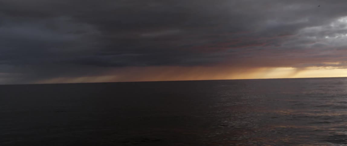 The ocean is empty with heavy clouds at dawn
