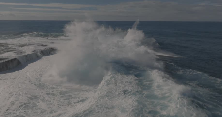 Aerial of waves moving in ocean water at dusk