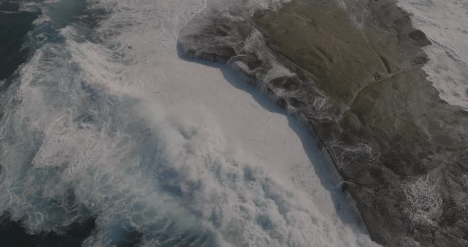 A big ocean wave hitting a rock