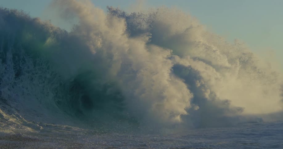 Slow motion ocean waves moving at sunset