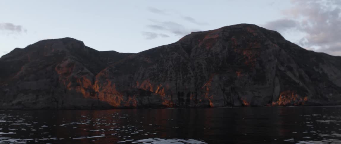 A mountain is surrounded by water