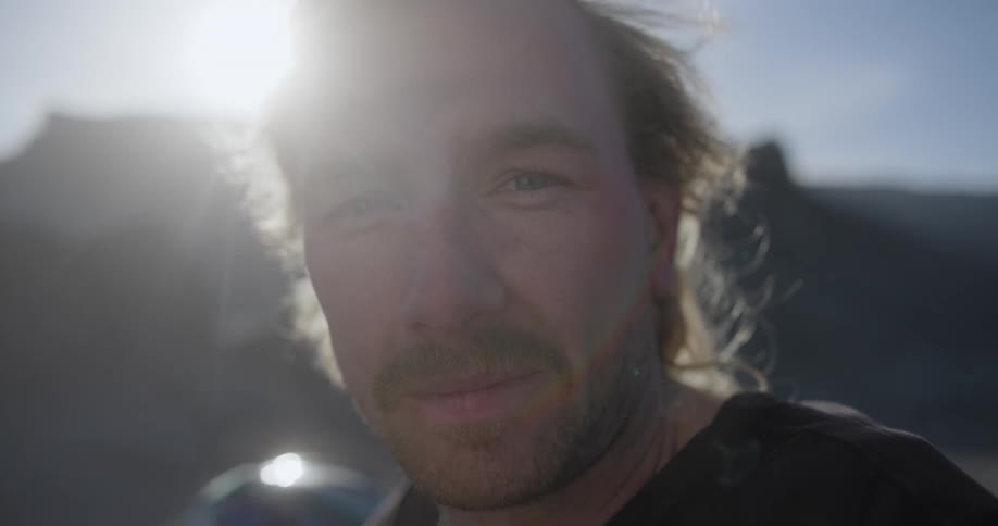 A man smiles on a windy day