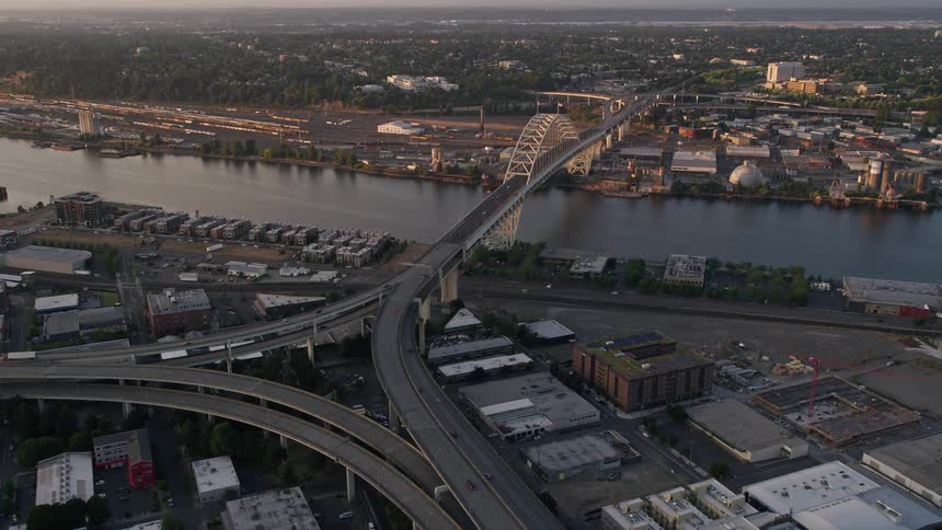  aerial footage capturing the mesmerizing sunset over Downtown Portland Oregon as cars approach the Fremont Bridge and freeway interchange