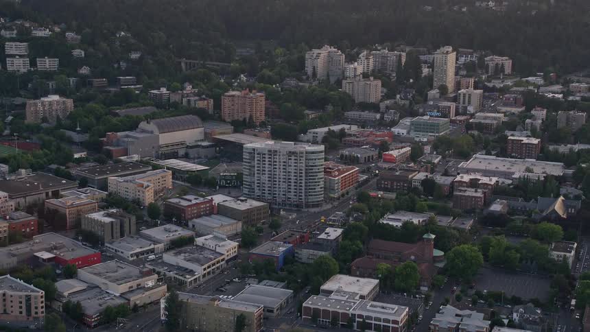 Approaching sunset aerial view of downtown Portland Oregon showcasing the Providence Park football stadium and condo complex in the metropolis