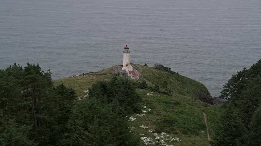 Aerial view of the North Head Light a lighthouse on top of a coastal mountain overlooking the Pacific Ocean in Ilwaco Washington during a sunny day in summer