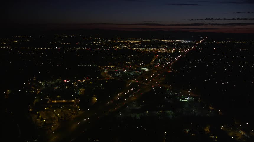 Aerial view of Beaverton Oregon at night showcasing a shopping center and Highway 26 with light traffic