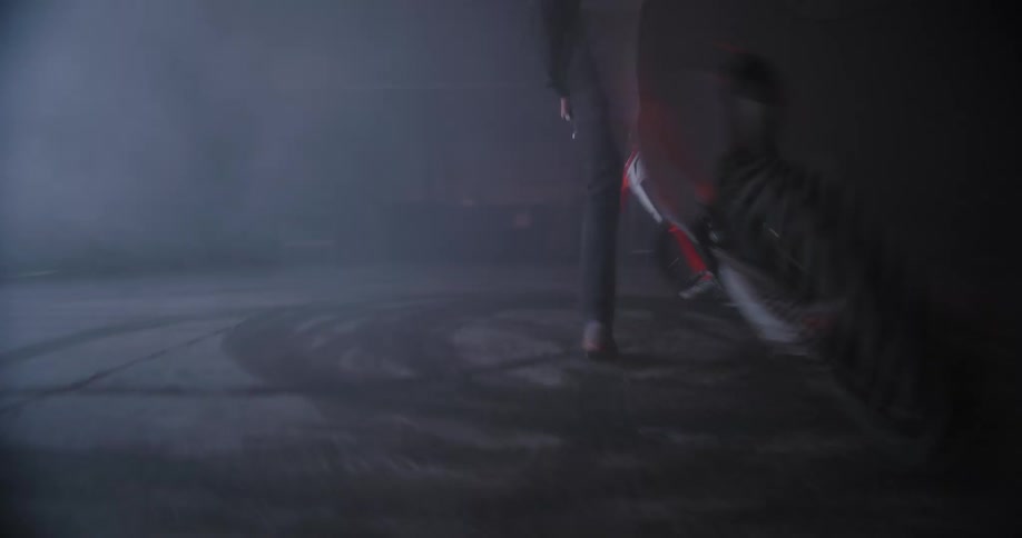 Man circles inside a small garage with a motorcycle