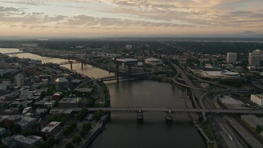 Aerial footage of Portland Oregon during twilight showcasing the Willamette River Rose Garden Arena and Memorial Coliseum