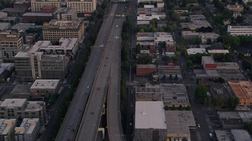 Aerial footage of vehicles on Interstate 405 track towards Downtown Portland Oregon at sunset revealing the city's skyscrapers