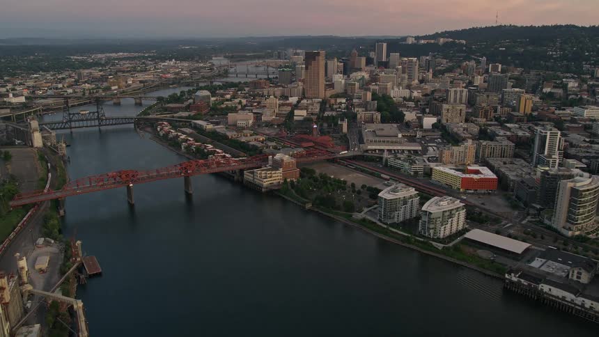Aerial twilight pan across Fremont Bridge revealing downtown Portland Oregon with high-rise buildings and city river