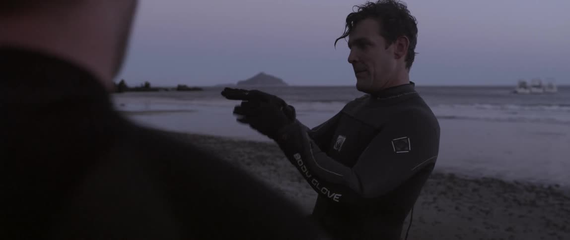 A man is talking to others on the beach