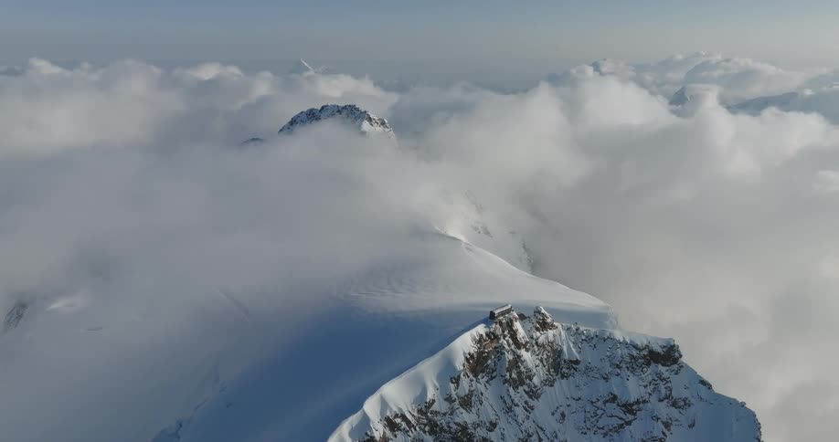 Snow covered mountains with clouds passing over them