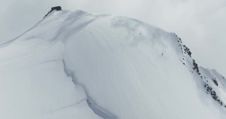 Aerial view of a snowcovered mountain with two people skiing