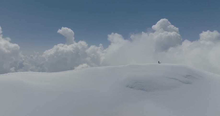 Aerial view of mountains at cloud level covered in snow