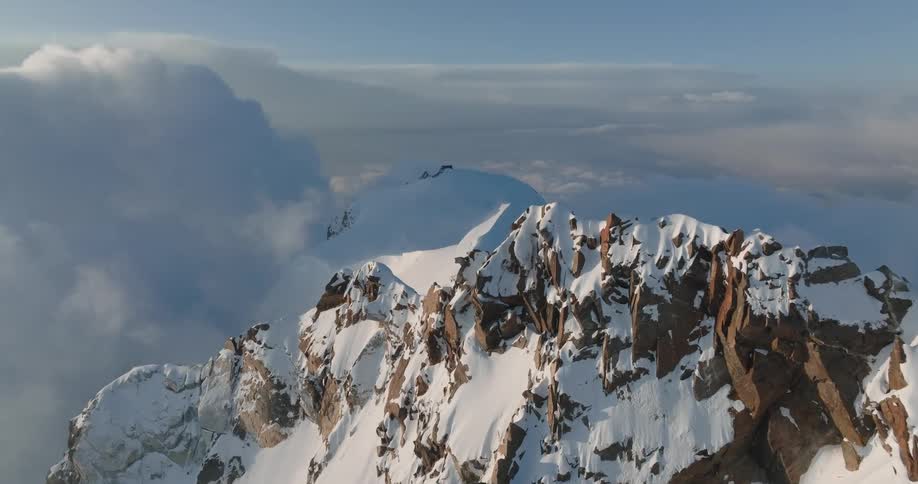 Clouds surround snow covered mountain