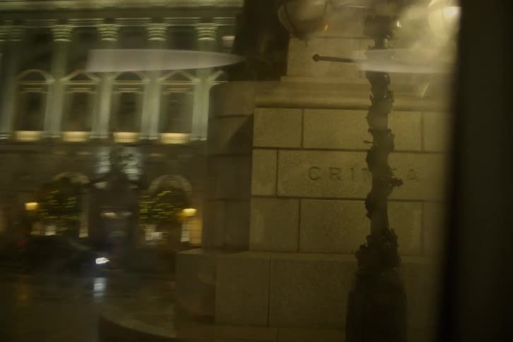 A touristic location in a square made of brick blocks while it rains