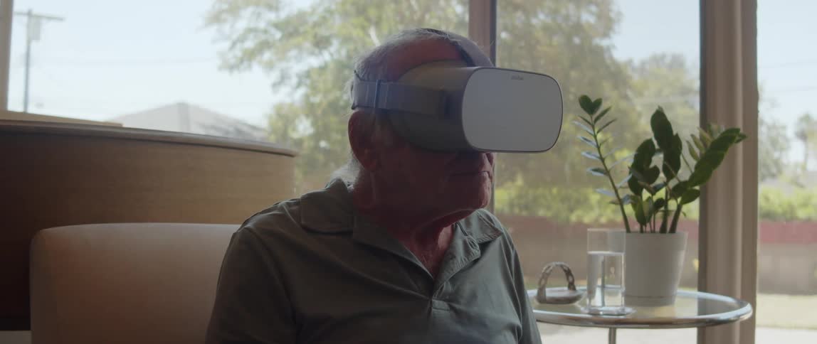 An elderly man wearing virtual reality glasses