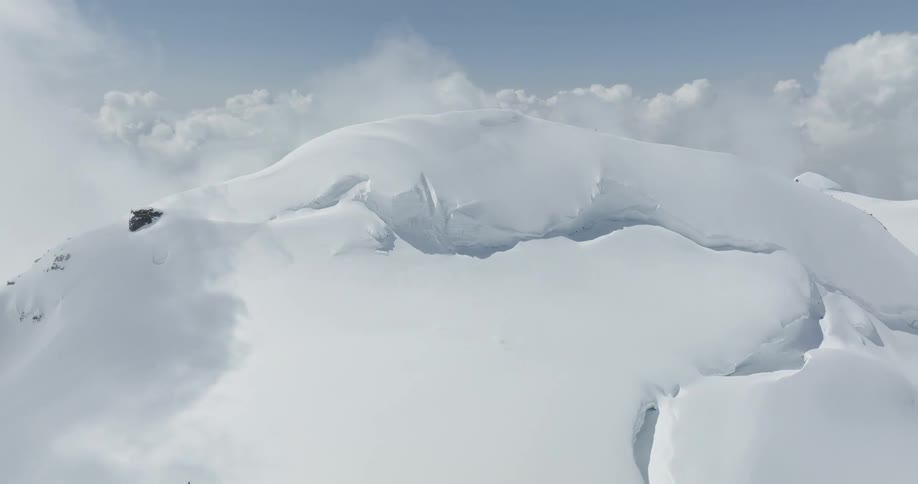 Mountain at cloud level covered in snow