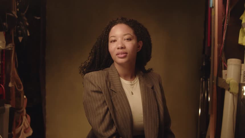 Sitting woman wearing gray blazer posing with happy facial expression