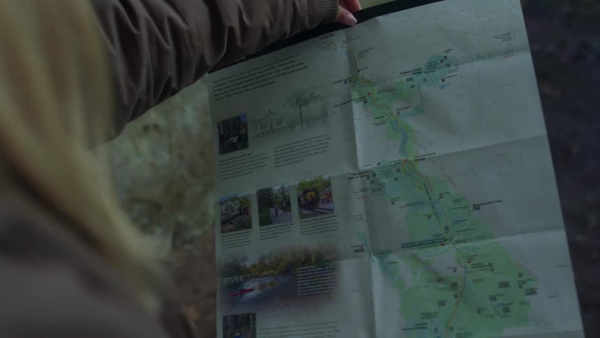A woman holding up a map to look at it