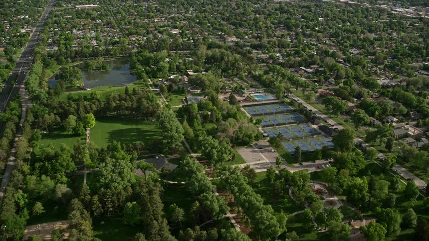 Aerial view of Liberty Park tennis courts and approaching suburbs in Salt Lake City Utah during a sunny day showcasing the recreational and leisure activities in the suburban community