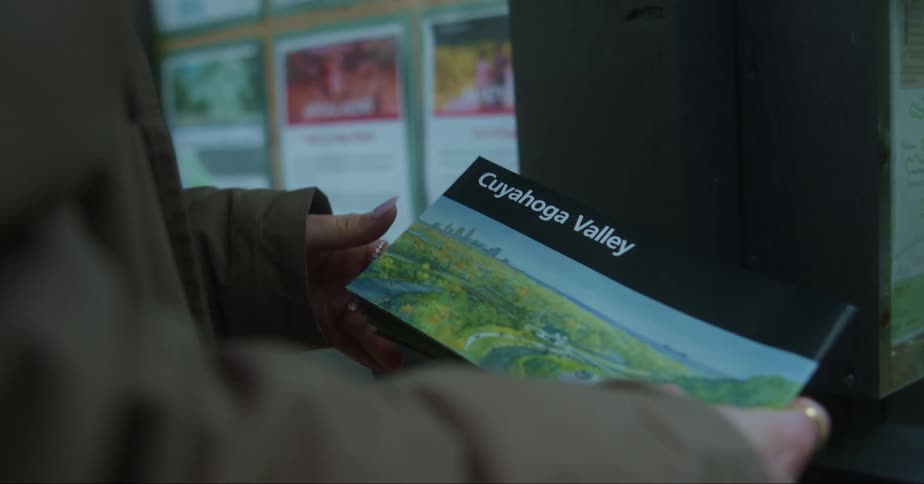 A woman picks up a brochure about the cuyahoga valley