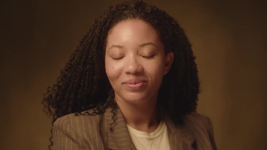A woman smiles while blinking her eyes