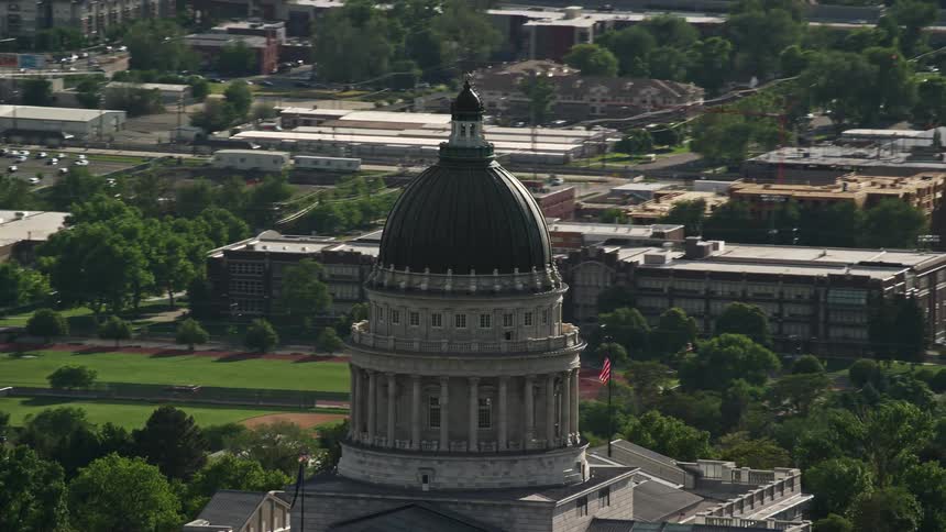 Aerial footage of the Utah State Capitol dome orbiting above Capitol Hill in Salt Lake City showing the government building sunny weather and bustling city streets
