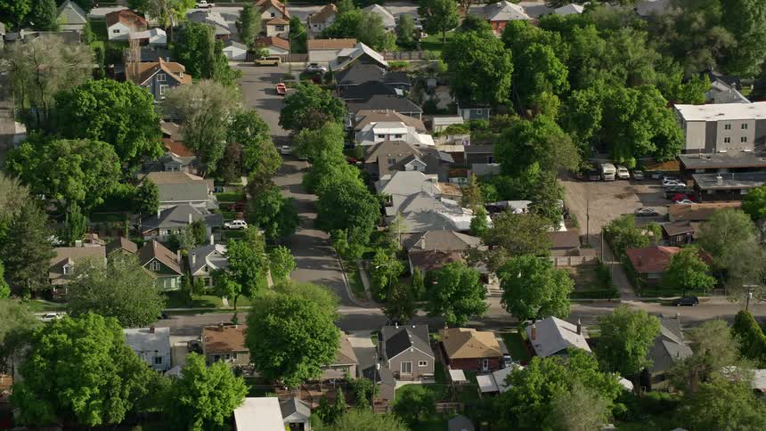 Aerial view of a suburban residential neighborhood with plenty of trees and houses in Salt Lake City Utah during summer