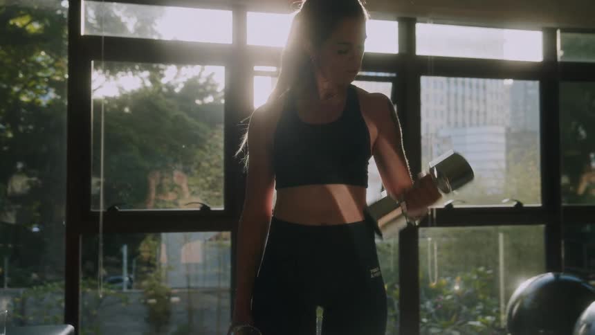 A woman does bicep curls with hand weights