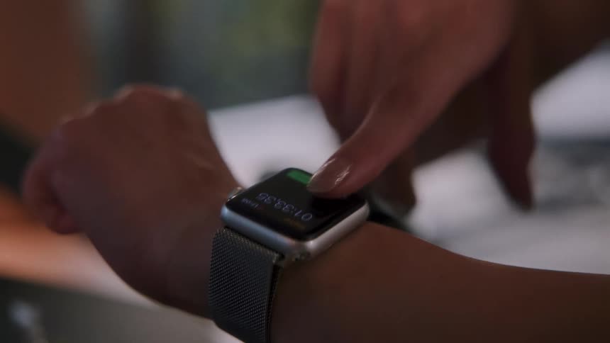 A woman taps the screen on her smart watch