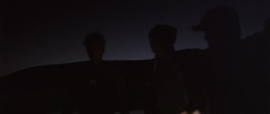 People are standing in the dark talking