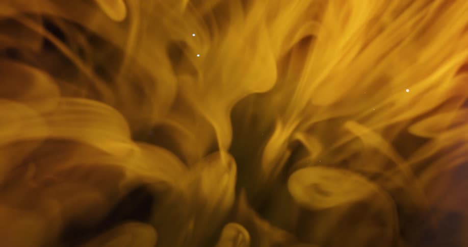 A flame of fire with characteristic smoke exploding in a black environment