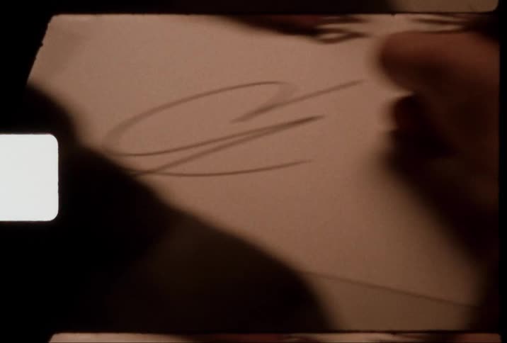 Closeup of a human hand scribbling a signature on a white paper